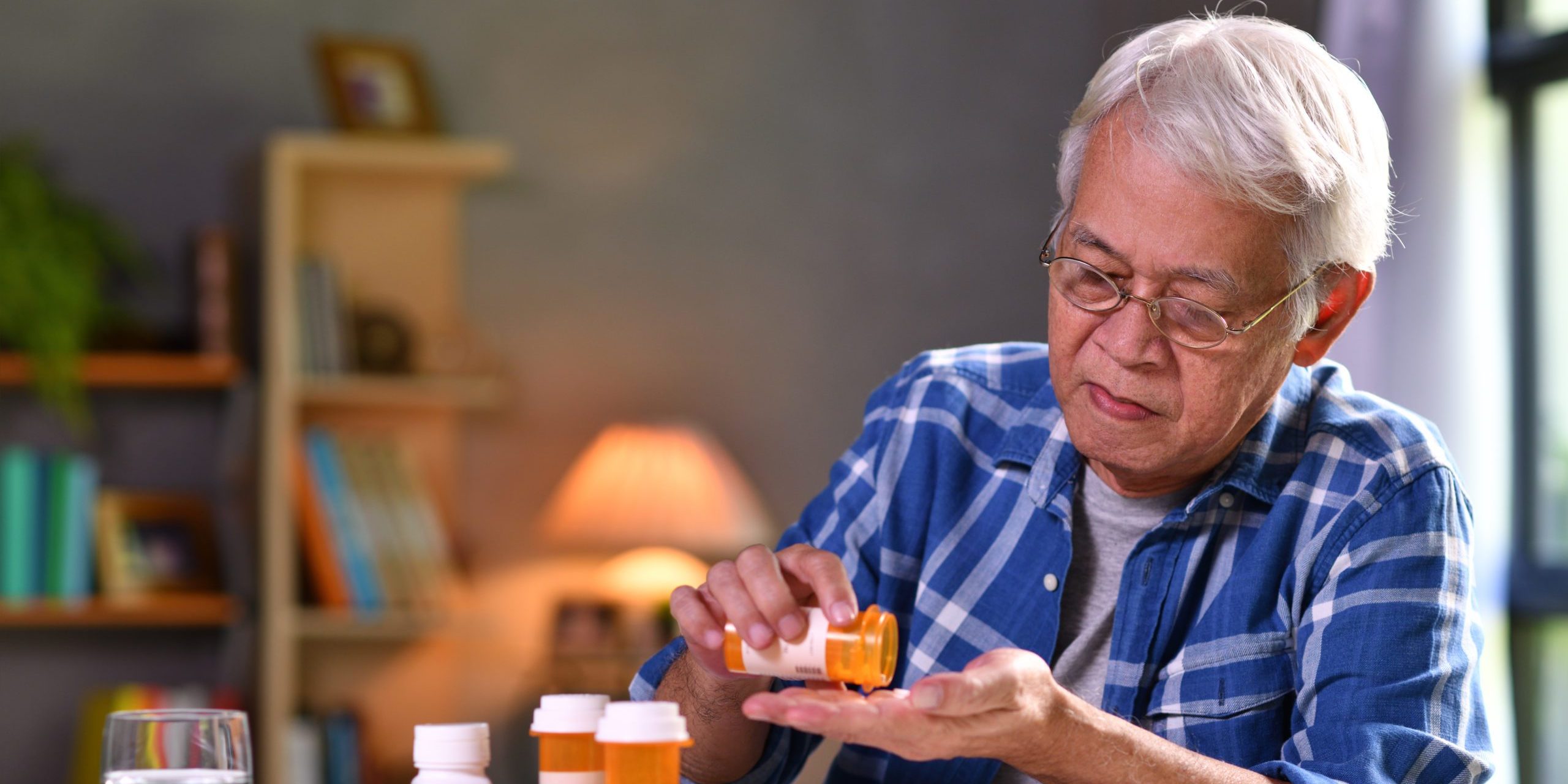 Asian Senior Man Taking Medicine At Home